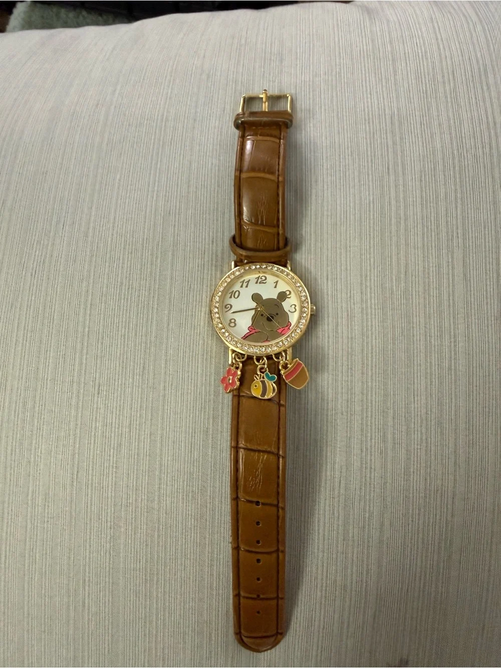 Disney Winnie the Pooh watch features a crystal-bezel dial and dangling charms o